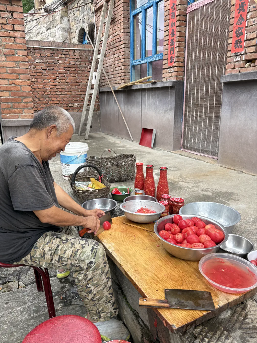村民在院中切番茄制作番茄酱
