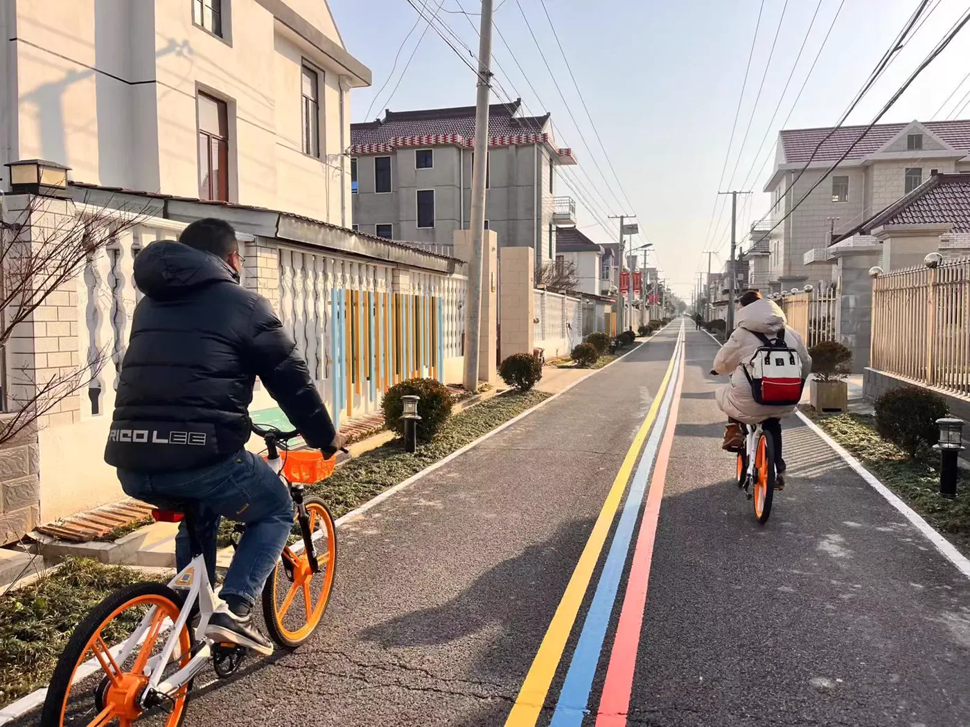 人们骑车经过鸿田村村路